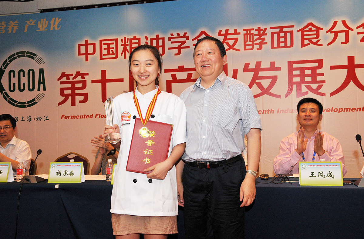 中国粮油学会发酵面食分会俞学锋会长为郑芃园颁奖。